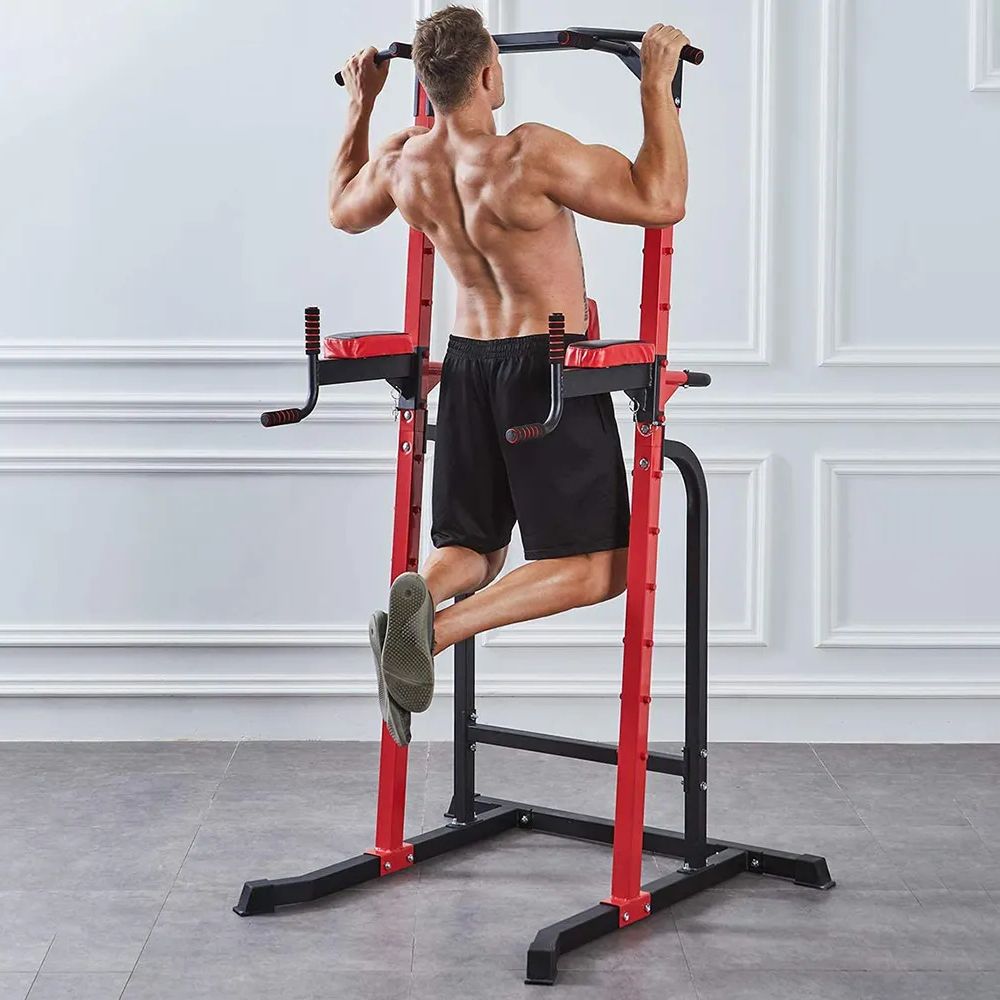 Man using a red pull-up bar in a home gym setting